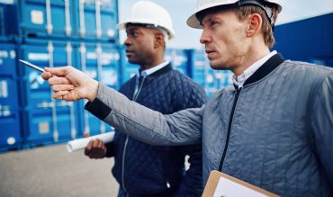 engineers-tracking-shipping-containers-in-a-large-E8YV5TM.jpg